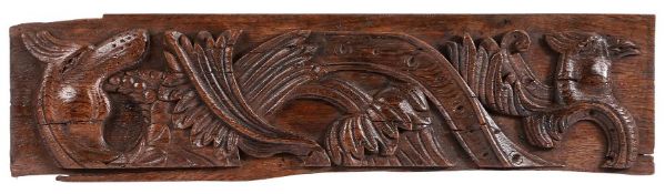 A 16th century carved oak panel Boldly carved with foliage, head of a cockatrice, and head of a