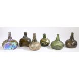 A collection of early 18th century glass onion bottles, English Various colours, one with seal,