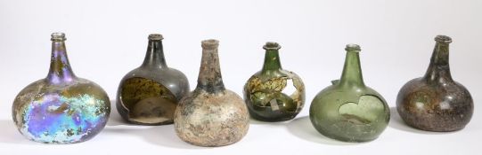 A collection of early 18th century glass onion bottles, English Various colours, one with seal,