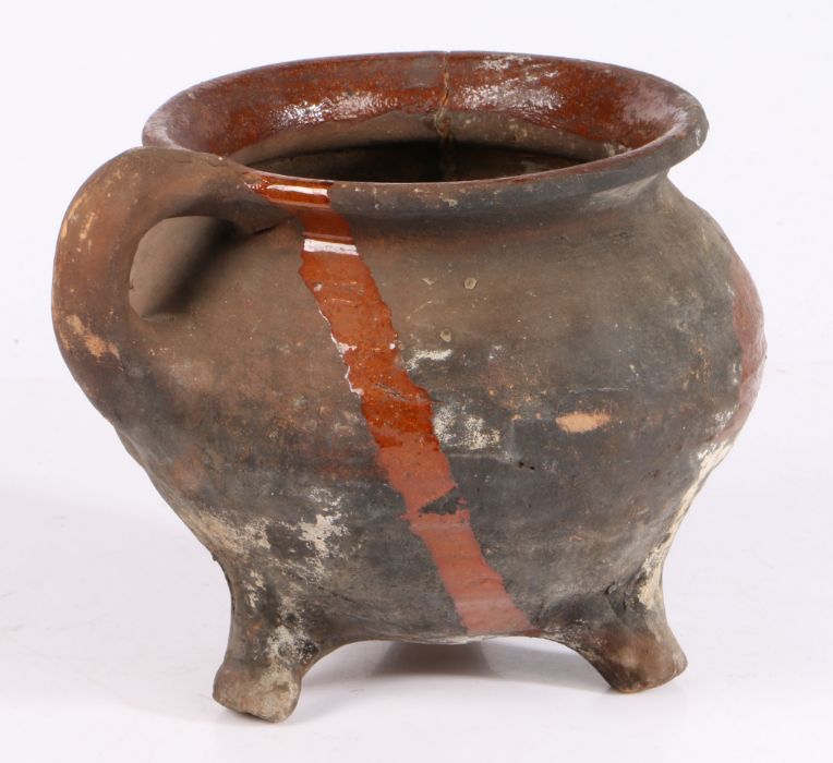 A 17th century Dutch pottery cauldron With ribbed body, loop handles and three dumpy feet,