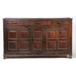 A George III oak fully-enclosed oak dresser base, circa 1760 The boarded top with shallow broad rear