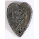 A lead trade weight, probably medieval, English Of heart-shape, with crossed implements, and the