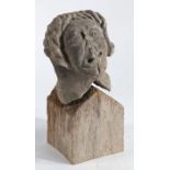 A late Medieval carved stone head Modelled as a wavy haired male with contorted mouth, on a later