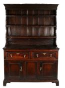 A George II oak enclosed high dresser, circa 1740 Having a slender boarded rack, with three shelves,