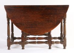 An 18th century oak drop-leaf table, English Having an oval drop-leaf top, wavy frieze, turned