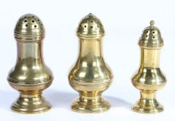 Three George III brass pepperettes, circa 1800 Each of baluster form, with flared foot and push-on