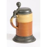 A mid-18th century pewter-mounted earthenware stein, German The domed lid engraved with initials and