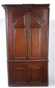 An oak barrel-back standing corner cupboard, circa 1800 The bold moulded cornice with key-stone,