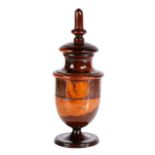 A George III lignum vitae coffee grinder, circa 1790 Having a tall finial above an urn-shaped body