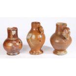 Three 16/17th century pottery jugs The first salt glazed example with bulbous body, handle