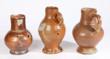 Three 16/17th century pottery jugs The first salt glazed example with bulbous body, handle