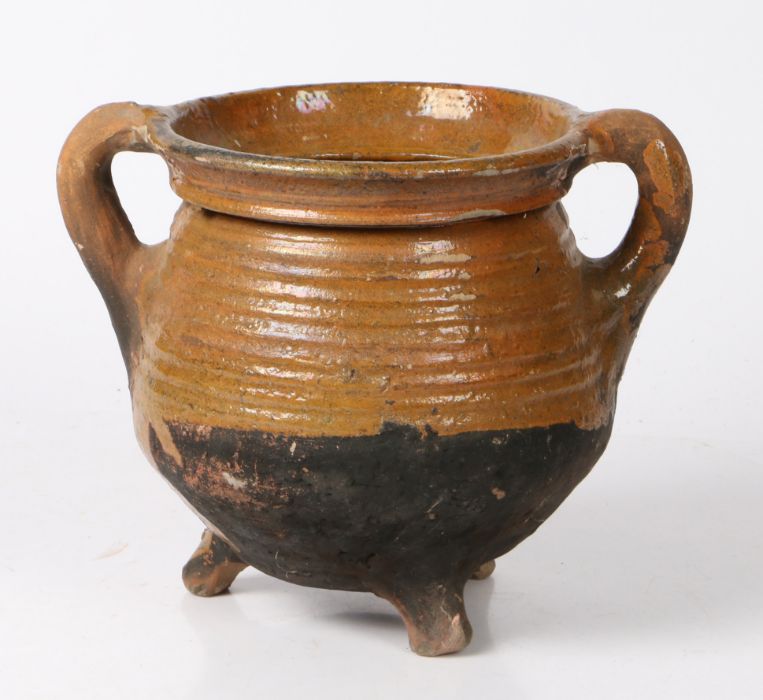 A 17th century Dutch pottery cauldron With a ribbed body and loop handles, on three dumpy feet, 20cm - Image 2 of 2