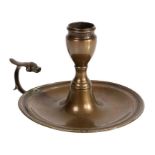 A George III reddish-brass chamberstick, circa 1780-90 Having an urn-shaped socket, a domed and