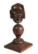 An early 17th century carved oak native African head appliqué, English Mounted on a sphere, and on