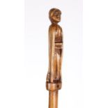 An 18th century treen baton The terminal carved as female figure with crossed arms, 50cm long