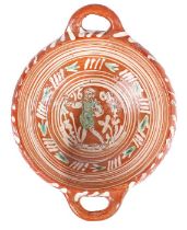 A Dutch slipware twin-handled bowl, dated 1604 The centre with a figure walking amongst trees, a
