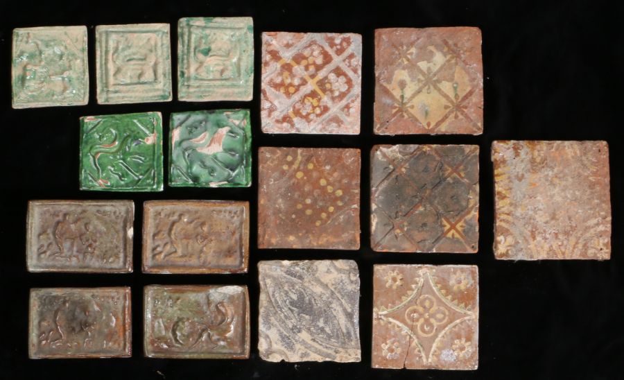 A collection of tiles To include slipware examples, green glazed examples with animals and a brown