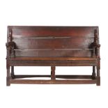 A Charles II oak table-settle, circa 1680 Having a boarded and end-cleated back/top, on four ball-