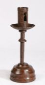 A 16th century iron socket candlestick, on an early 19th century lignum vitae base  Having a