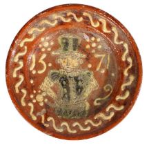 A Dutch slipware dish, dated 1571 Centred by a bearded figure wearing a tall hat, with sunburst