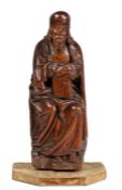 A 14th/15th century carved oak figure of a Saint, possibly St. John Modelled leaning on a ‘stall',