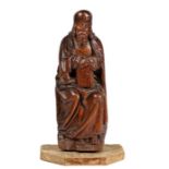 A 14th/15th century carved oak figure of a Saint, possibly St. John Modelled leaning on a ‘stall',