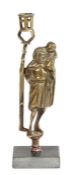 An early 16th century style brass figural candlestick, in the circa 1500 manner The figure dressed