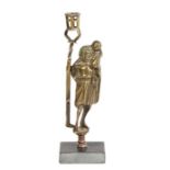 An early 16th century style brass figural candlestick, in the circa 1500 manner The figure dressed