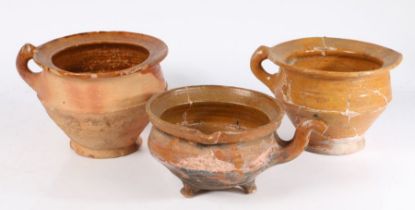 Three 17th century Dutch pottery pots To include two with a wide lip and loop handle above a tapered