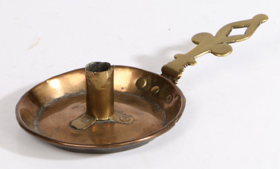 A brass and copper chamberstick, English, circa 1700 The circular copper pan with flared and