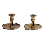 A near pair of George III cast brass chambersticks, circa 1780 Each with tulip-shaped socket with