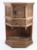 An oak dressoir, in the early 16th century manner, French Of canted form, having a cupboard enclosed
