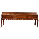 A George II fruitwood open dresser base, circa 1750 The top mainly of one wide board with ovolo-