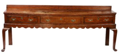 A George II fruitwood open dresser base, circa 1750 The top mainly of one wide board with ovolo-