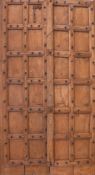Pair of Indonesian hardwood doors, each door with twelve simulated panels surrounded by raised metal