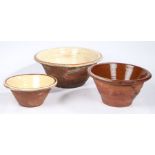 Two slip ware bowls, each with glazed interiors with a brown band to the rim, and one other bowl,