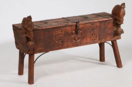 An Indonesian hardwood coffer, the foliate and roundel carved hinged lid flanked by two horse head