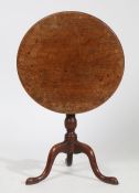 George III mahogany tilt top occasional table, raised on gun barrel column and tripod legs with