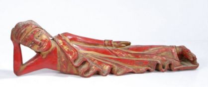 Indian wooden Deity, 20th century, in red lacquer and gilt decoration, modelled in a lying position,
