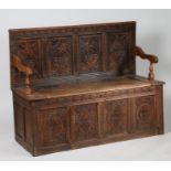 19th century oak settle, the back rest with carved diamond lozenge and foliate panels, with hinged