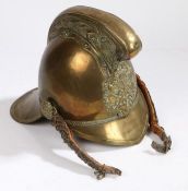 A 19th Century brass fireman's helmet, with crossed axe and entwined hoses emblem to the front