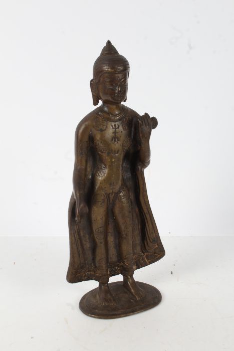 Burmese bronze figure depicting Buddha, modelled in a standing position with left arm raised, 30cm