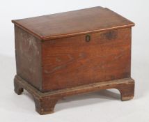 George III oak coffer bach, the hinged lid enclosing a candle box interior, raised on bracket
