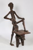 An unusual African hardwood chair, modelled as two figures forming the back, arms and legs, 145cm