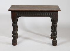 An oak occasional table, the rectangular top above a lunette carved frieze, raised on turned legs,