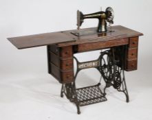 A Singer treadle sewing machine, with three side drawers, on a cast iron base, 92cm wide