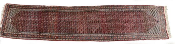 A Large Hamadan runner, North West Persia, baring a signature, set with repeating floral guls,