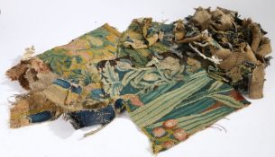 A collection of 17th and 18th Century verdure tapestry fragments, to include flowers, reeds,