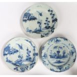 Three 18th Century English Delft chargers, to include a near pair in blue decoration with a Oriental