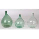 Three French claret flasks, to include two olive green and a clear example, 45cm high. 50cm high and